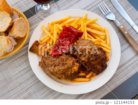 Pork knuckle with potatoes and stewed bell peppers close up 121144153