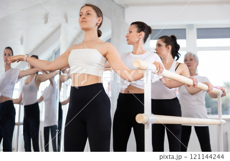 Group of women practicing at ballet barre 121144244