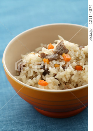 茶碗に乗せたご飯と具材を一緒に炊く日本料理の炊き込みご飯 茶碗に乗せたご飯と具材を一緒に炊く日本料理の炊き込みご飯 121144874