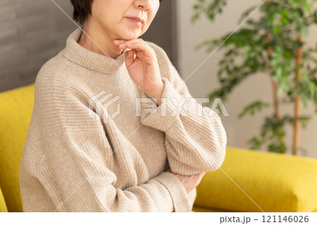 家のリビングで悩むミドル〜シニア女性 121146026