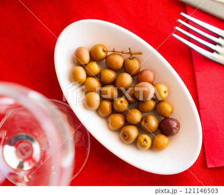 Light snack - bowl with pickled green olives 121146503