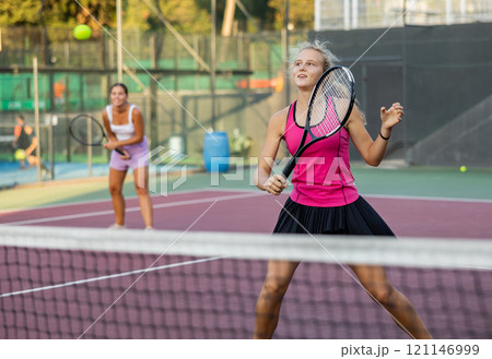 Girl playing tennis match during training on court Girl playing tennis match during training on court 121146999