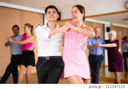 Young happy couple performing a paired dance in ballroom Young happy couple performing a paired dance in ballroom 121147129