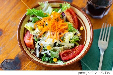 Plate contains portion of salad from fresh China cabbage, carrot, corn Plate contains portion of salad from fresh China cabbage, carrot, corn 121147149