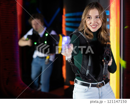 Young lady having fun playing lasertag in arena Young lady having fun playing lasertag in arena 121147150