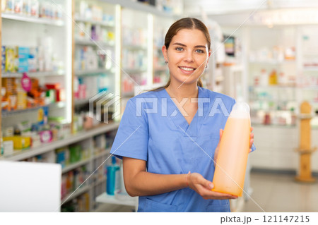 Pharmacist showing bottle with haircare product Pharmacist showing bottle with haircare product 121147215