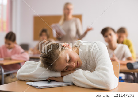 Teenager girl sleeping during lesson 121147273