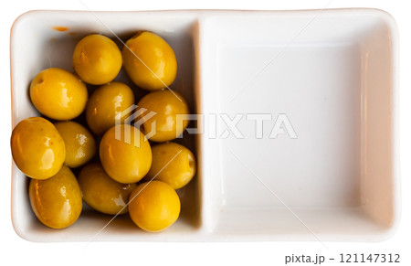 Green olives with pits served in bowl 121147312