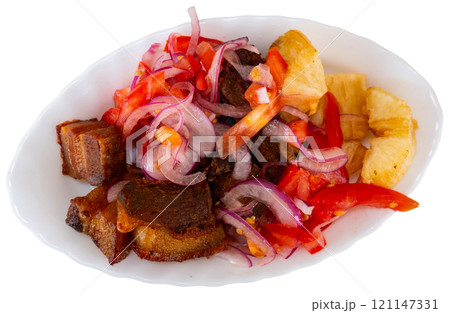 Fried pork is laid out on plate, with fried cassava and salad - Latin American tapita dish. Fried pork is laid out on plate, with fried cassava and salad - Latin American tapita dish. 121147331