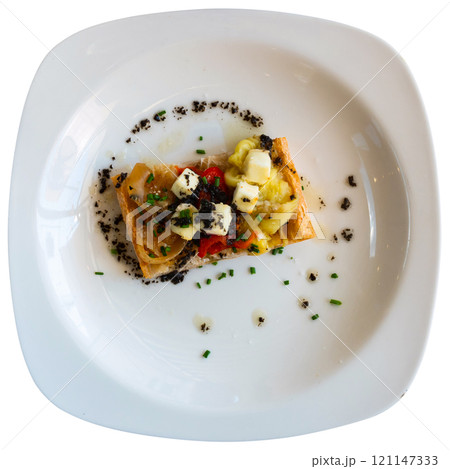 Plate contains sandwich made from of French baguette, stewed Escalibada vegetables, of goat cheese 121147333