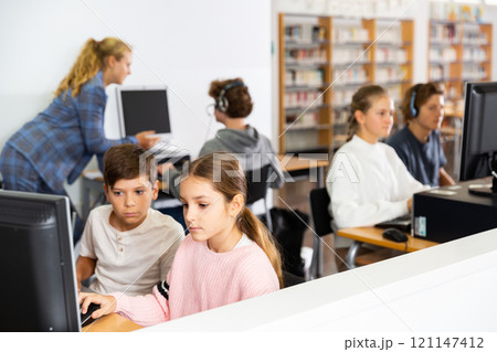 Teenagers in computer class 121147412