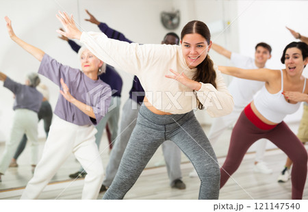 Group of adult people practices dance aerobics Group of adult people practices dance aerobics 121147540