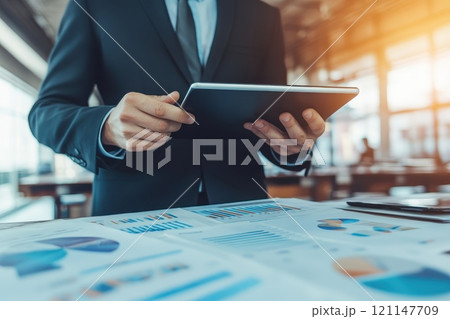 A man in a suit is holding a tablet A man in a suit is holding a tablet 121147709