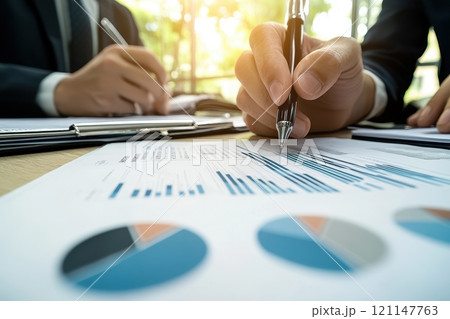 Business Meeting with Reports and Charts in Modern Office Environment Business Meeting with Reports and Charts in Modern Office Environment 121147763