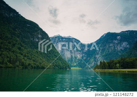 Konigssee Lake in Bavaria Germany with Church by the Lake White Boat Forested Mountain and Beautiful Sunny Trekking in Berchtesgaden German Alps. High quality photo Konigssee Lake in Bavaria Germany with Church by the Lake White Boat Forested Mountain and Beautiful Sunny Trekking in Berchtesgaden German Alps. High quality photo 121148272