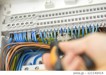 Electrician repairing faulty wiring 121148414