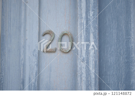 A weathered, rustic wooden door showcasing the number 20 in a charming and decorative style A weathered, rustic wooden door showcasing the number 20 in a charming and decorative style 121148872