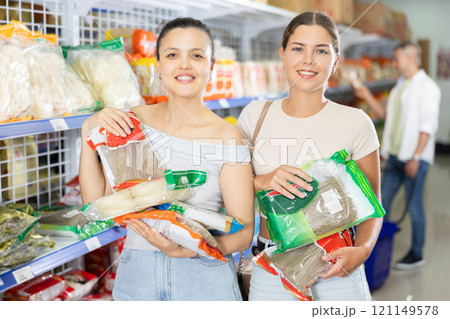 Two women choosing noodles in store Two women choosing noodles in store 121149578