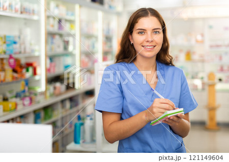 Pharmacist in drugstore with notebook Pharmacist in drugstore with notebook 121149604