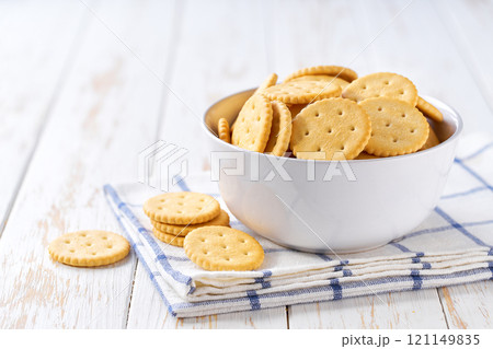 Delicious round crackers in a plate with on a light kitchen table, selective focus. Delicious round crackers in a plate with on a light kitchen table, selective focus. 121149835