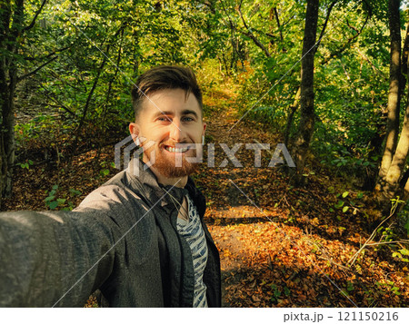 Handsome man is taking a selfie outdoor - caucasian people - nature, people, lifestyle and technology concept 121150216