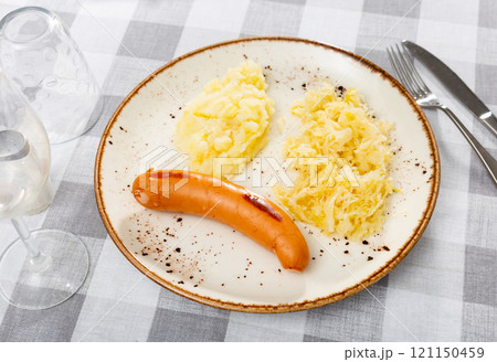 Sausages served with potatoes and cabbage Sausages served with potatoes and cabbage 121150459