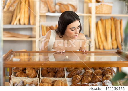 Young female customer choosing croissants in bakery Young female customer choosing croissants in bakery 121150523