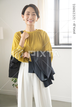 屋内でバッグとジャケットを持つ女性 121150931