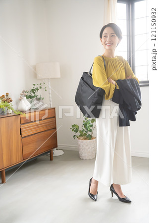 屋内でバッグとジャケットを持つ女性 屋内でバッグとジャケットを持つ女性 121150932