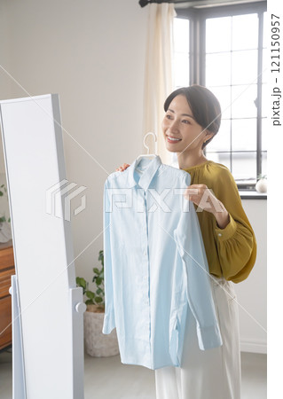 部屋で洋服を選ぶ女性 121150957