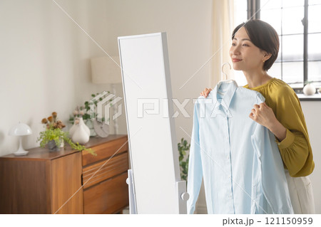 部屋で洋服を選ぶ女性 部屋で洋服を選ぶ女性 121150959