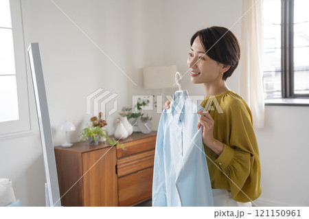 部屋で洋服を選ぶ女性 部屋で洋服を選ぶ女性 121150961