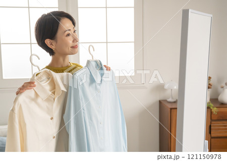 部屋で洋服を選ぶ女性 部屋で洋服を選ぶ女性 121150978
