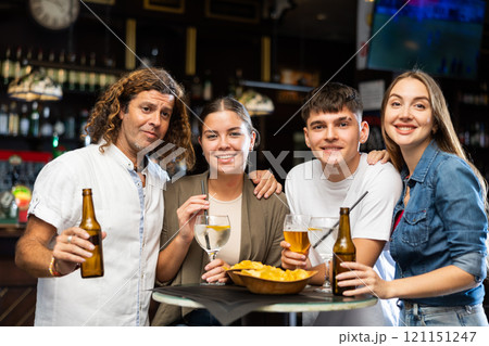 Portrait of happy friends in beer bar chatting and drinking beer 121151247