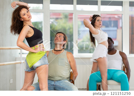 Woman performing sensual lap dance with man on chair at group rehearsal Woman performing sensual lap dance with man on chair at group rehearsal 121151250