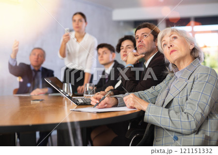 Mature female entrepreneur watching presentation during business training 121151332