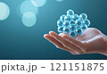 Hand holding a 3D molecular structure model against a blurred blue background, AI 121151875