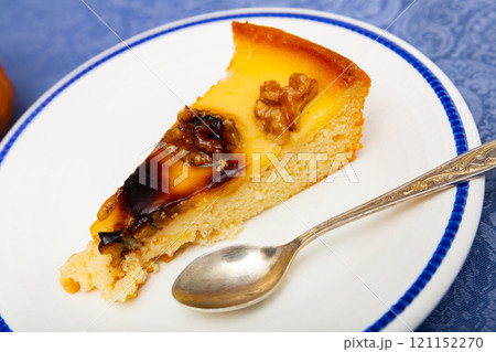 Piece of pie with walnuts served in a plate 121152270