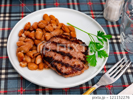 Beef burger patty served with beans Beef burger patty served with beans 121152276