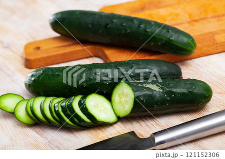 Whole and sliced fresh cucumbers 121152306