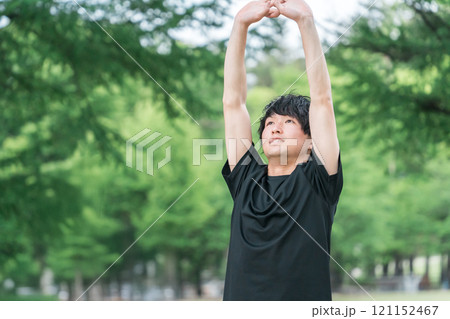 深呼吸するスポーツウェア姿の若い男性（森林浴・ストレス解消・気分転換・朝活・準備運動・日光浴） 121152467