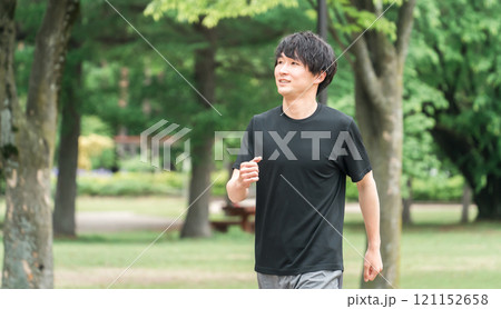 公園でウォーキング・ジョギング・ランニング・運動・有酸素運動・トレーニングをする若い男性 121152658