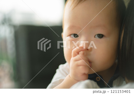 指を口に入れている赤ちゃん 指を口に入れている赤ちゃん 121153401