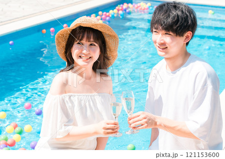 バカンス・リゾートホテルのプールサイドでシャンパングラスで乾杯するカップル バカンス・リゾートホテルのプールサイドでシャンパングラスで乾杯するカップル 121153600