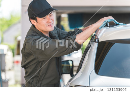 洗車するつなぎを着た整備士の男性 洗車するつなぎを着た整備士の男性 121153905
