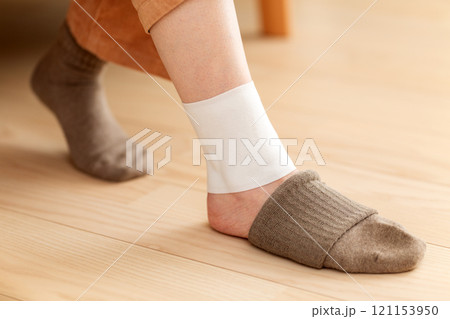 足首に湿布を貼るミドル〜シニア女性 121153950