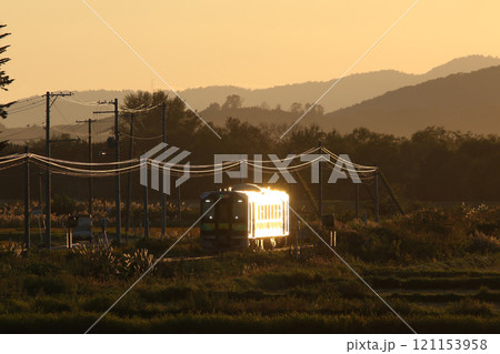 秋の夕日にボディを輝かせ走る石北本線普通列車列車　JR北海道一般形気動車　H100　DECMO 121153958