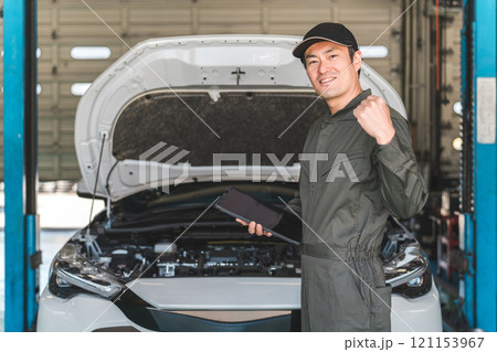 タブレットを使って自動車のエンジルームをチェックする自動車整備士の男性メカニック タブレットを使って自動車のエンジルームをチェックする自動車整備士の男性メカニック 121153967