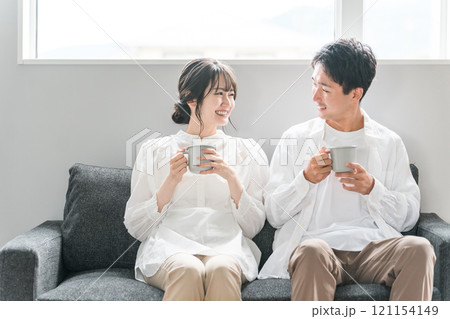 家のリビングのソファでくつろぐ夫婦・カップル・パートナー・家族 121154149