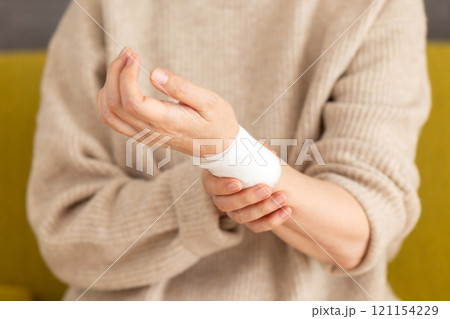 包帯が巻かれた手首を押さえるミドル〜シニア女性 121154229